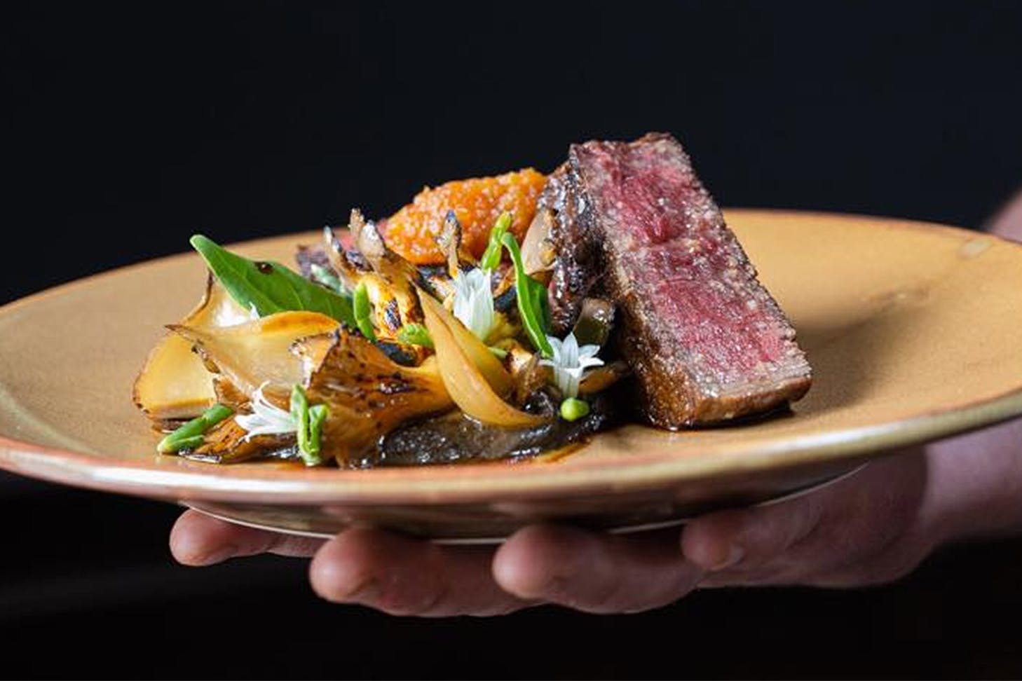 Wagyu Beef, Oyster Mushroom, XO, Pickled Onion on a plate from Clarence Bistro.